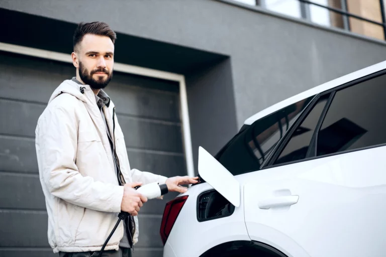 Man charging electric car by his house